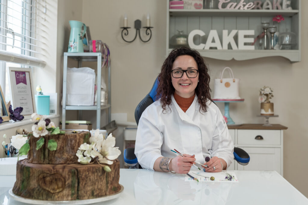 Debbie Lock cake designer decorating a cake - Little Barn Cakes